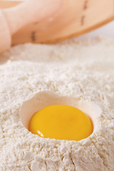 egg yolk in flour, rolling pin ang sieve on background