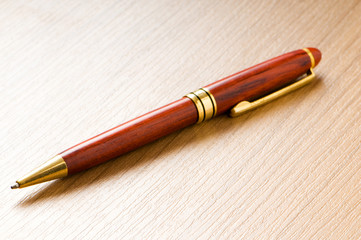 Fototapeta premium Writing silver pen on the wooden background