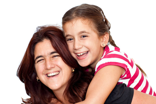 Small girl and her young latin mother hugging and laughing on a