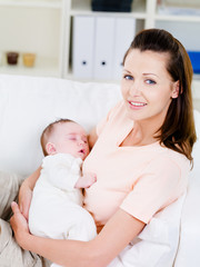 Fototapeta na wymiar Woman holding slepping newborn baby on hands
