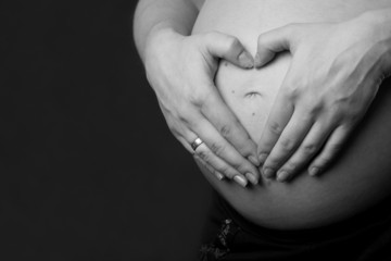 Pregnant woman with hands over tummy