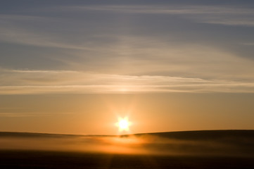 Obraz premium Meadow in a fog and in rising sun beams