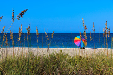 Colorful Beach Umbrella on a sandy beach with blue sky and ocean