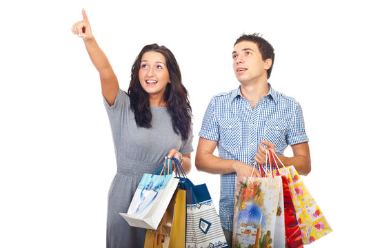 Surprised couple at shopping pointing up