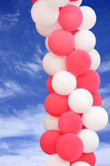 Fototapeta na wymiar Pink and white balloons on blue sky