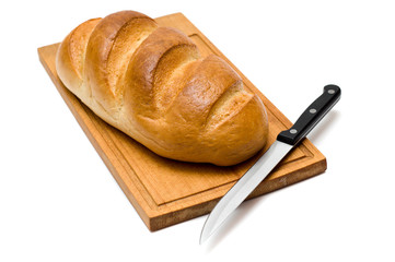 fresh bread with knife on breadboard