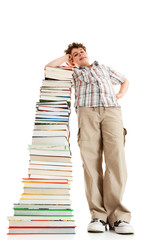 Student standing close to pile of books on white