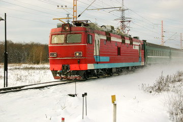 Winter. Siberia. The red locomotive and passenger train. Russia