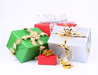 Gifts in silver, green and red wrapping with bows on white