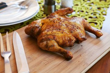 Whole cooked chicken with cutlery and spices