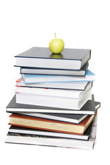 pile of books with apple on top over white