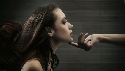 Conceptual image of a hand holding a woman's head - obrazy, fototapety, plakaty