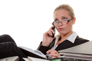 überlegende frau am schreibtisch beim telefonieren