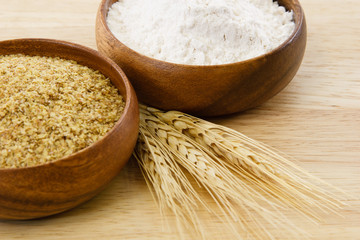 Two wood bowls with four and wheat germ