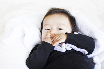 指しゃぶりをする乳児