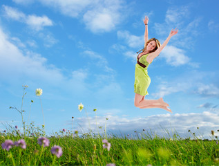 Young woman jumping in the meadow