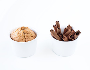 cake and cinnamon sticks in white cups