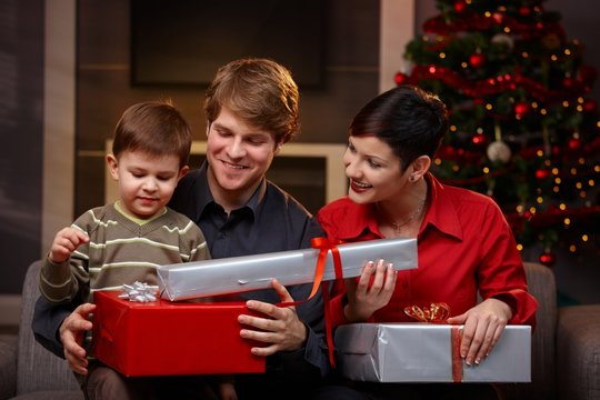Happy parents giving christmas gifts to son
