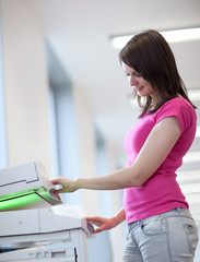 pretty young woman using a copy machine (shallow DOF; color tone