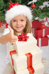 Happy little girl with lots of christmas presents