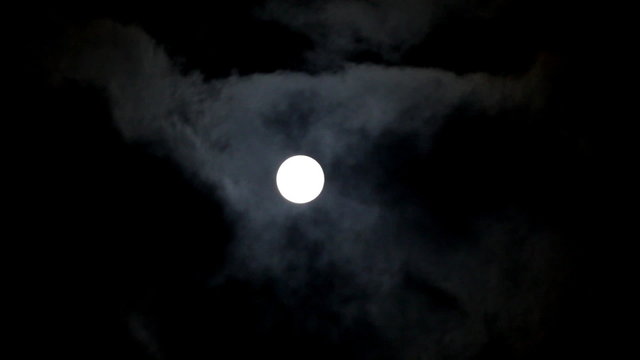 moon moving between clouds