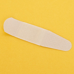 Single adhesive bandage on yellow background