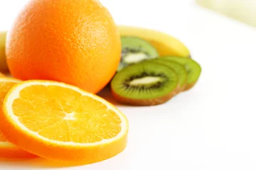 Fotobehang Plakjes fruit Fruitmix - sinaasappel, banaan, kiwi en sinaasappelschijfjes