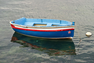 Naklejka na ściany i meble Small, blue rowboat moored in a marina