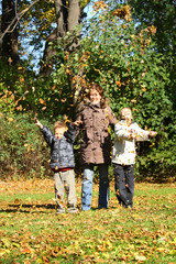 Mothers and children in autumn park.