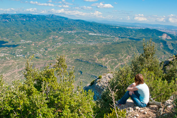 Naklejka premium Girl sitting on a cliff