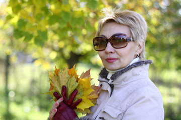 Woman in the sunglasses in the autumn park