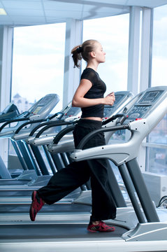 Young Woman At The Gym. Run On A Machine