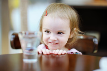 Adorable smiling toddler girl at cafe