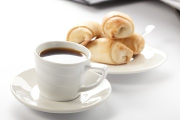 Cup of coffee with a roll