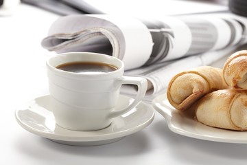 Cup of fragrant coffee on a morning paper business news