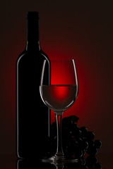 bottle with red wine and glass and grapes