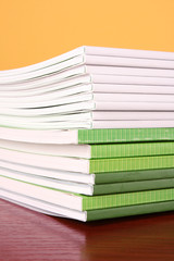 Pile of color magazines isolated on yellow background