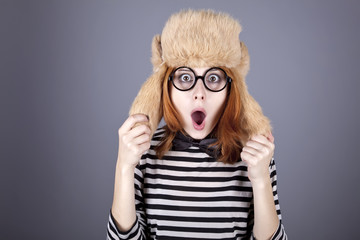 Surprise girl in winter cap and glasses.