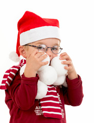 Junge mit Weihnachtsmütze und Schneebällen