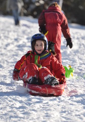 Fototapeta na wymiar sport d'hiver descente d'enfants joyeux en luge