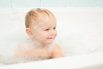 cute adorable baby play with foam in bath