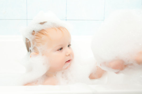 cute adorable baby play with foam in bath