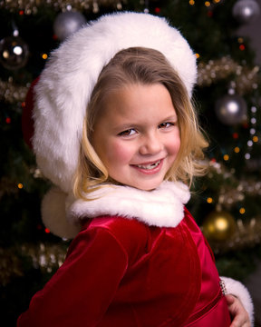 Adorable little girl in a Santa dress wearing a Santa Hat