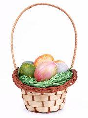 Colored easter eggs in a basket isolated