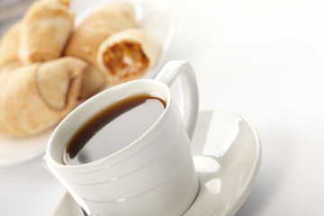Cup of coffee with a roll