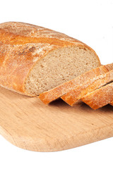 Fresh bread sliced on a wooden chopping board isolated on white