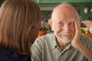 Senior couple at home focusing on man