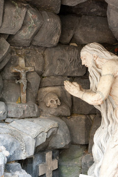 Monument praying elder in a cave