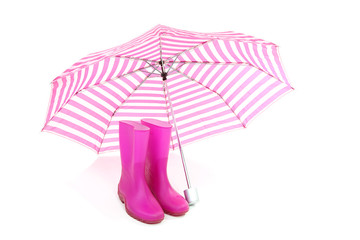 pink umbrella and rain boots over white background