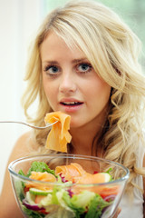Obraz na płótnie Canvas Teenage Girl Eating Smoked Salmon Salad. Model Released